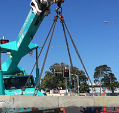 Teal Crane Lifting Concrete Block — Cranes in Mackay, QLD